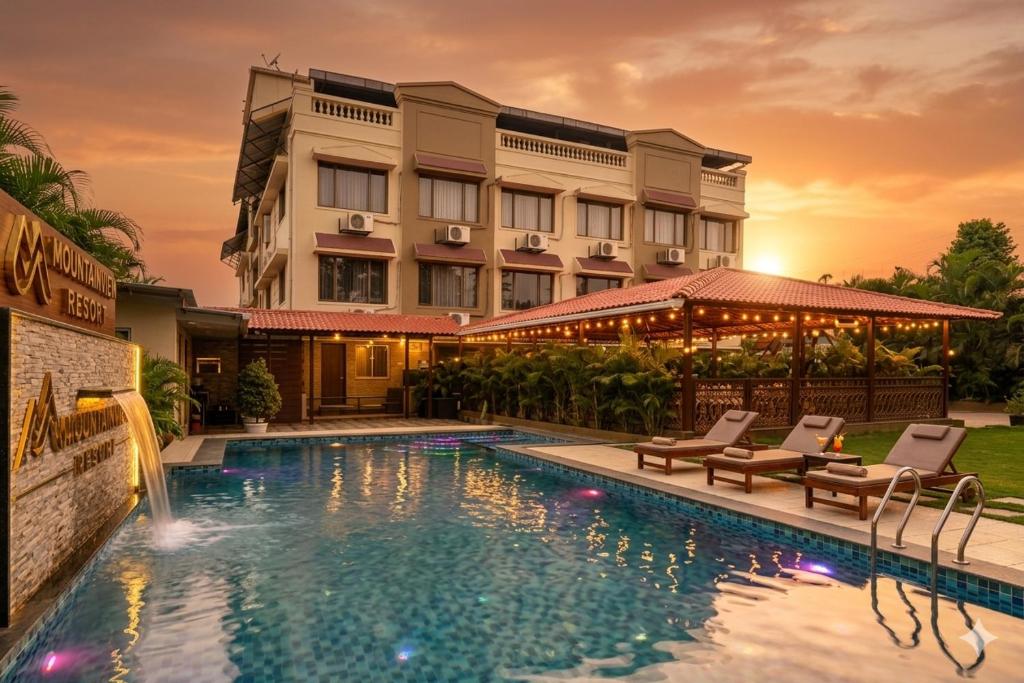 a hotel with a swimming pool in front of a building at Mountview Resort in Lonavala