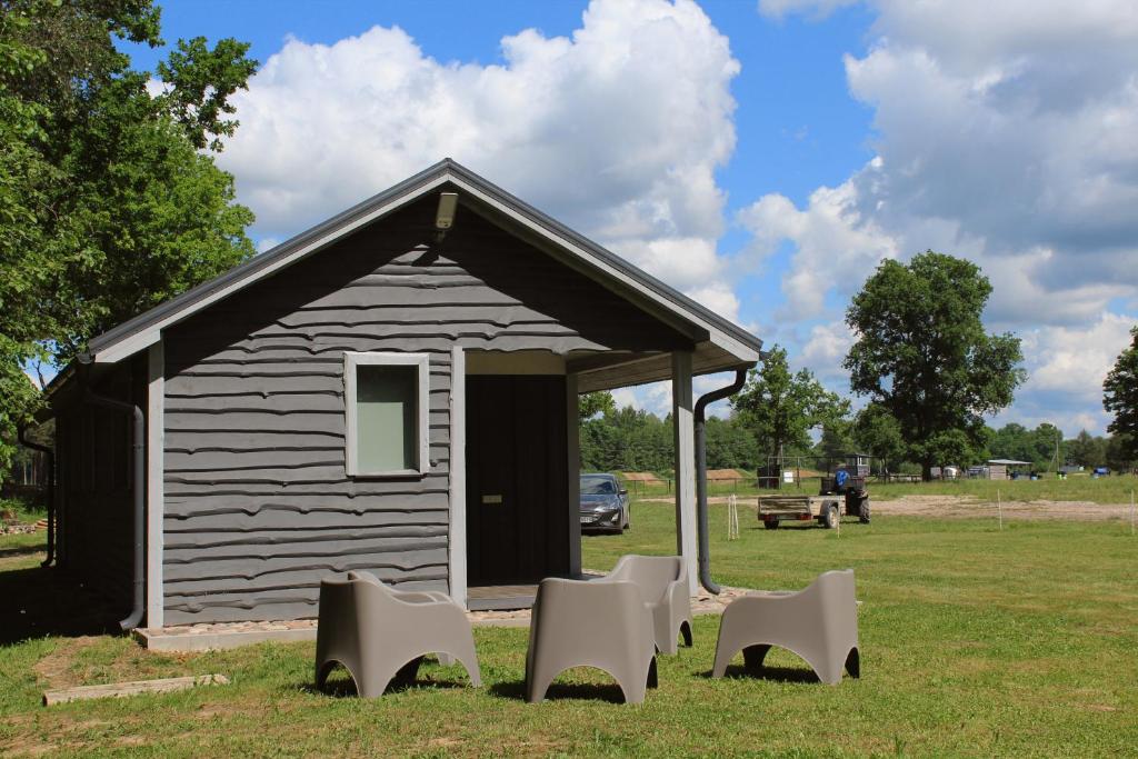 a small shed with chairs in front of it at Lubānas mototrase in Lubāna