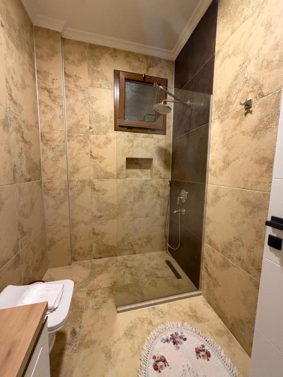 a bathroom with a shower with a toilet and a sink at Villa Lost dalaman in Çakallık