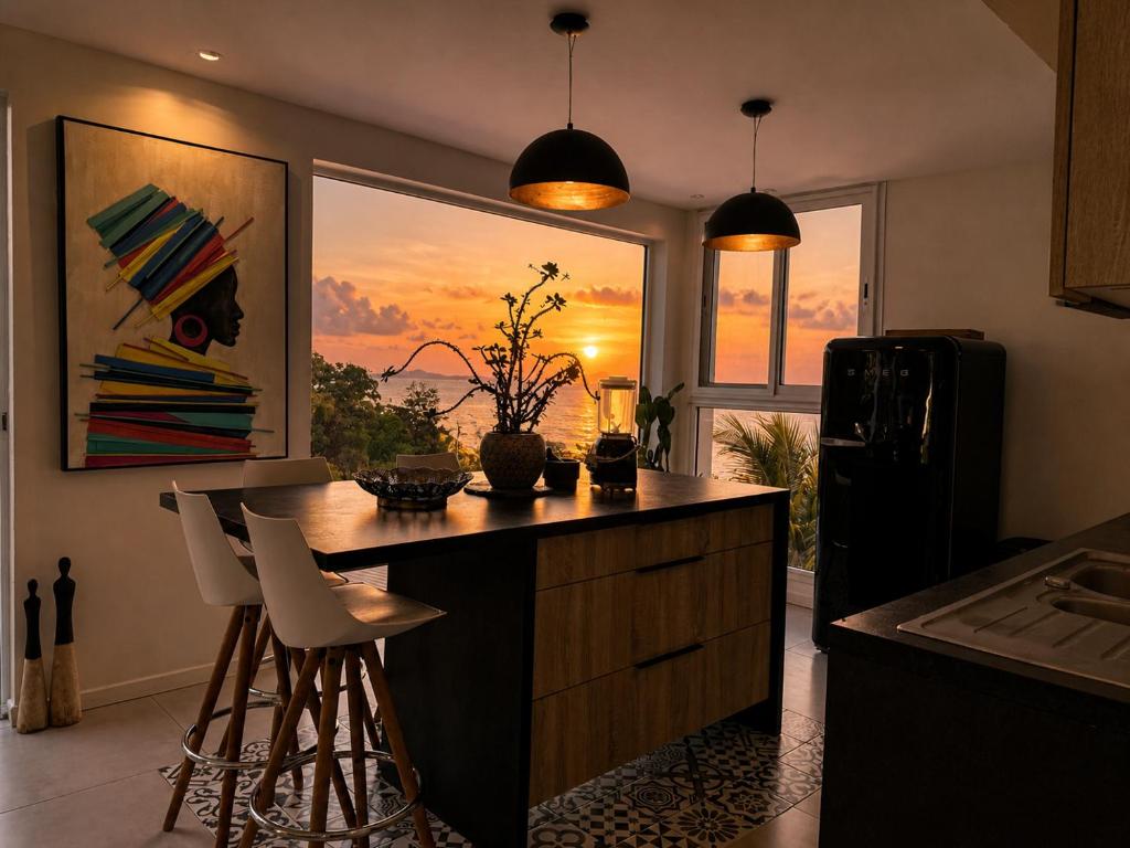a kitchen with a kitchen island with chairs and a window at Résidence Nakiya in Sainte-Marie