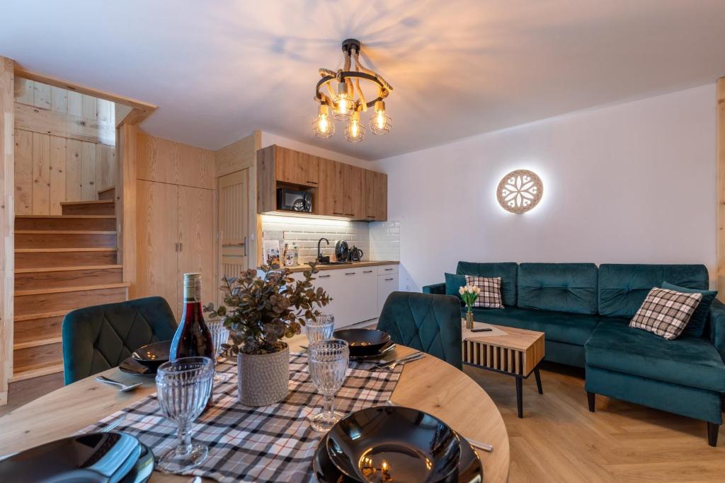 a kitchen and living room with a table and chairs at Apartamenty Wiktorówka in Poronin