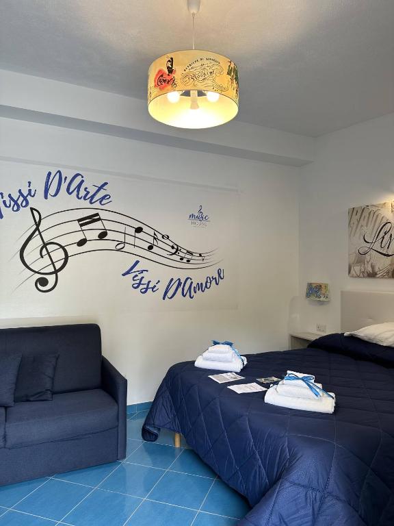 a bedroom with a bed and a couch and a sign at Music House Palinuro in Palinuro