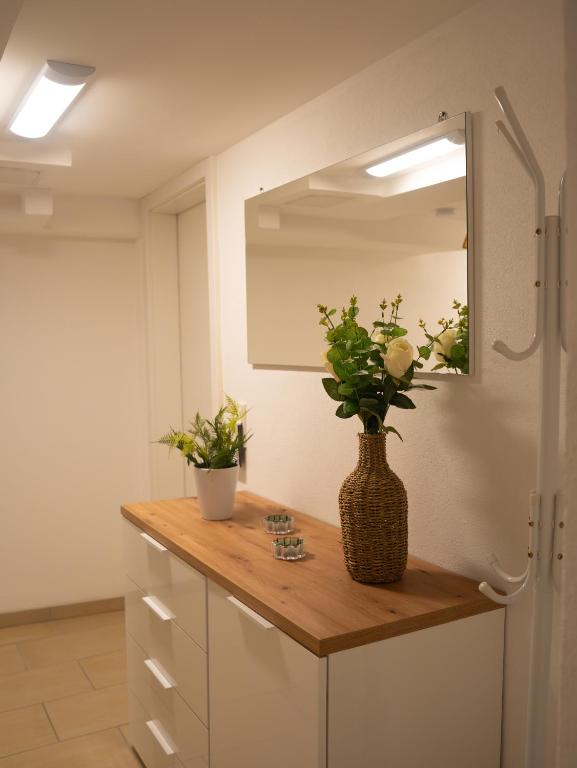 a bathroom with a counter with a vase of flowers on it at Ferienwohnung Carl in Weikersheim
