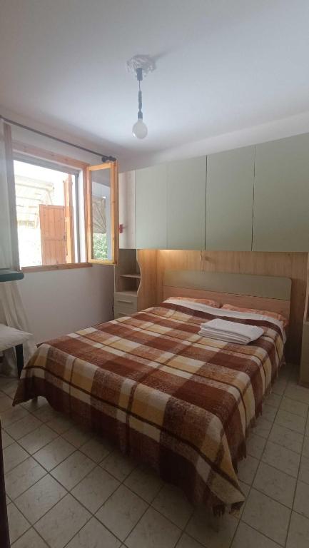 a bedroom with a large bed with a plaid blanket at Pomposa 41 in Lido di Pomposa