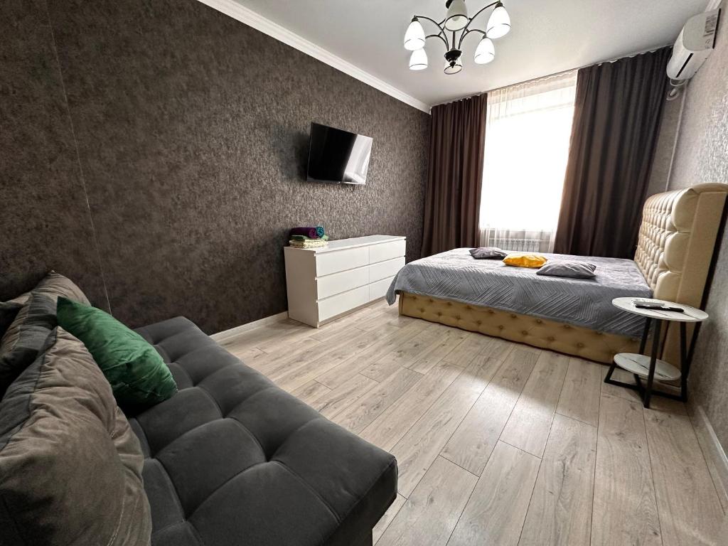 a living room with a bed and a couch at 1 комн.квартира in Balqash