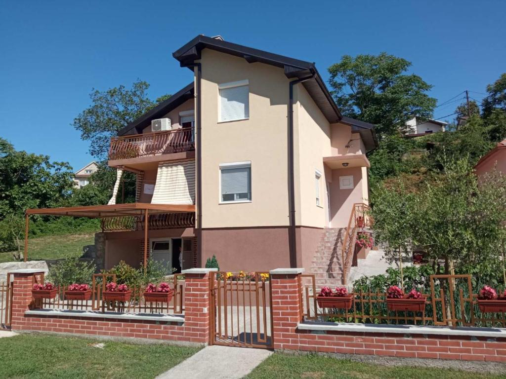 a house with a brick fence and flowers at Cicvaric rooms in Virpazar