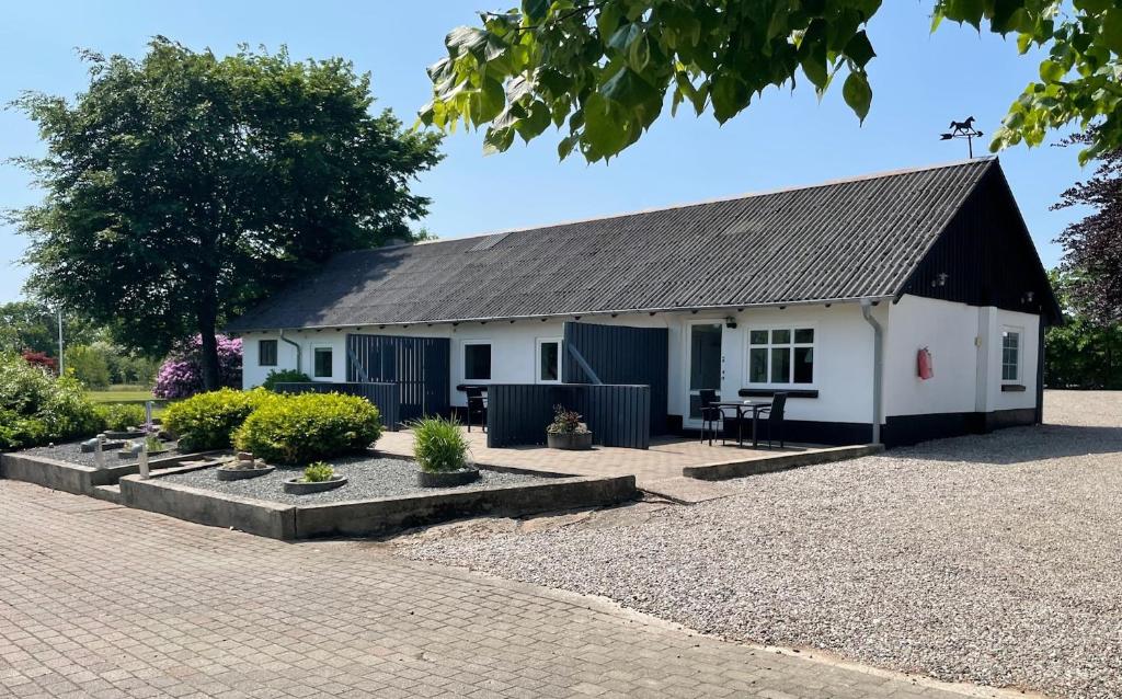 a small white and black building with a patio at Marskferie Tønder in Tønder