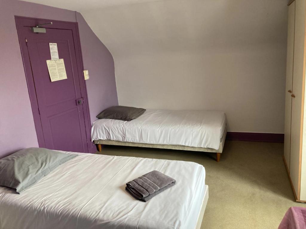a room with two beds and a purple door at Le bouf tard chambre vue sur jardin CH7 in Vendôme