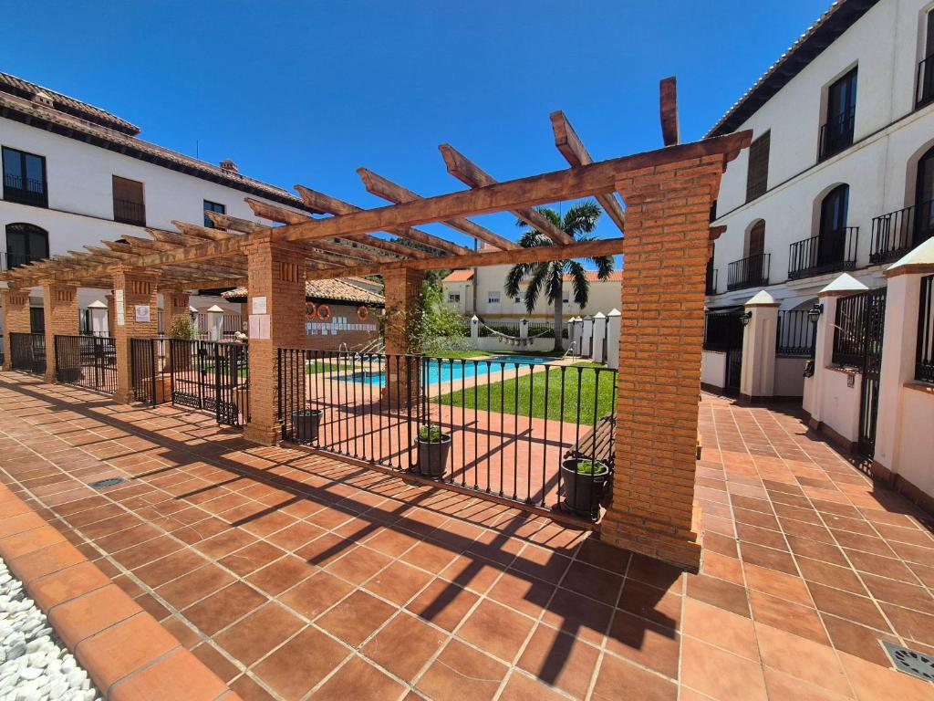 a brick pergola in a courtyard with a pool at 2 Duplex Las Terrazas Cubes in Vélez de Benaudalla