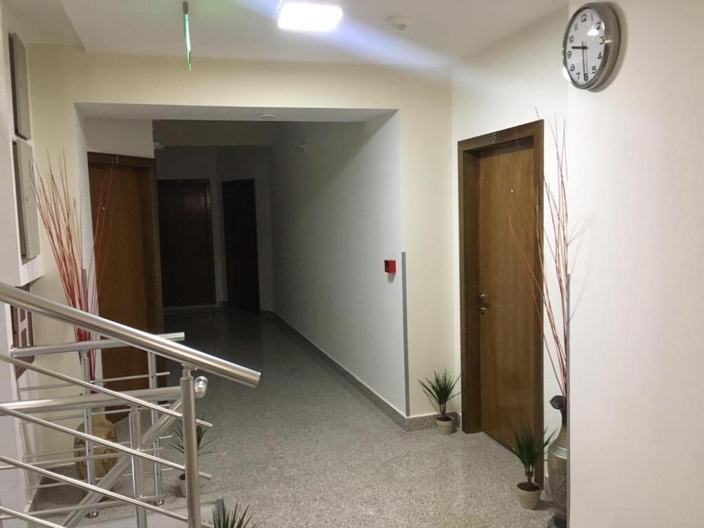 un corridoio vuoto con un orologio appeso a un muro di Hotel Restoran EPI a Valandovo