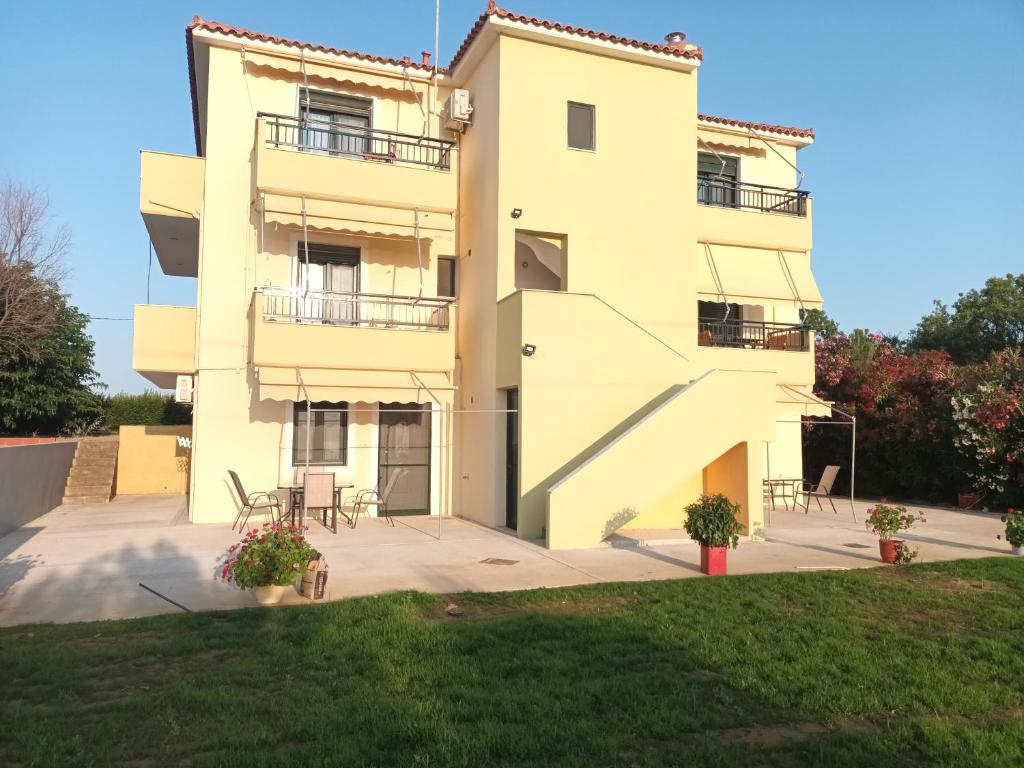 a large white building with two balconies at Panorama Apartment 1 in Moúdhros