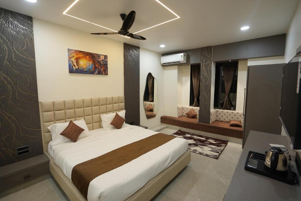 a bedroom with a bed and a ceiling fan at Ace Inn Hotel in Nagpur