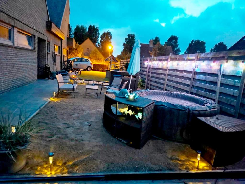 a patio with a fireplace and a table and chairs at Smiley in Blankenberge