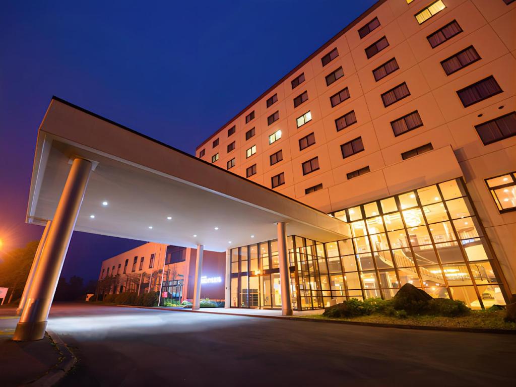 a large building at night with its lights on at Livemax Resort Hakodate Shikabe Onsen in Shikabe