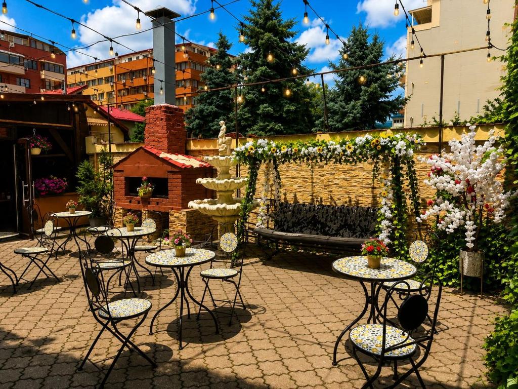 a patio with tables and chairs and a fountain at Pensiunea Passion in Bucharest