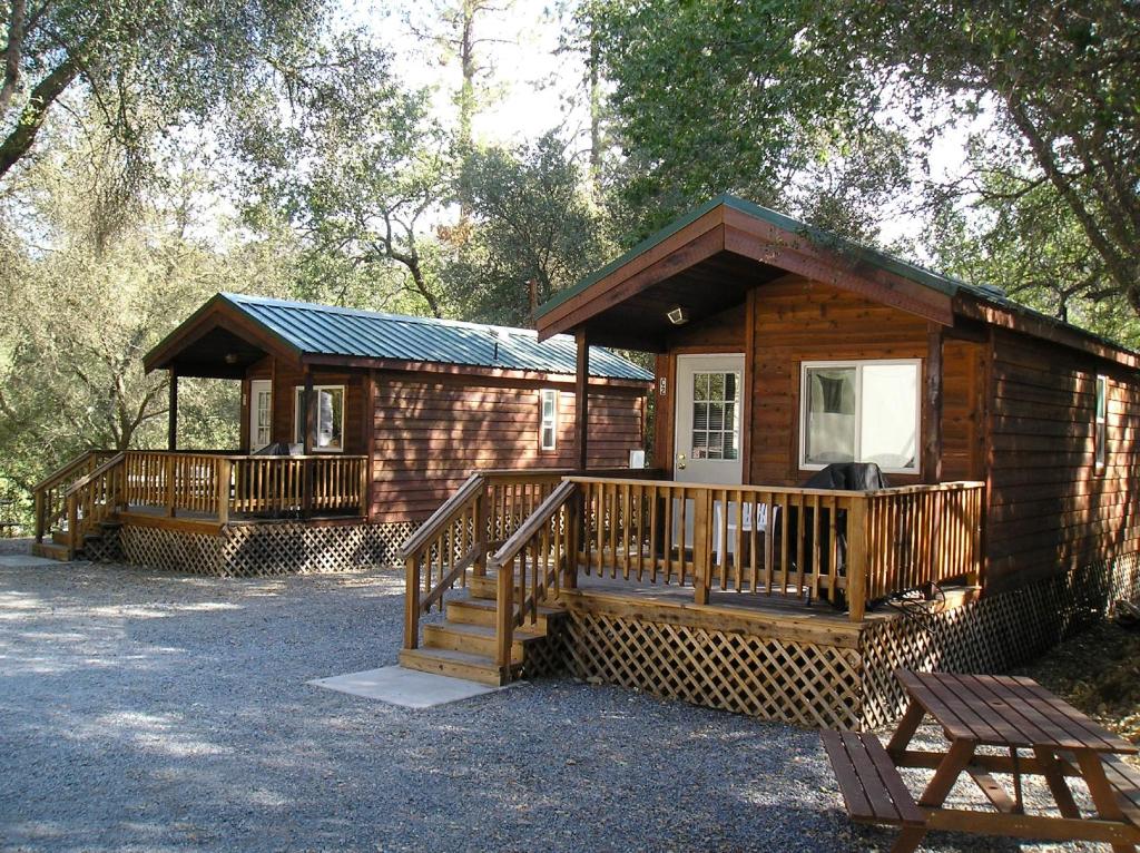 LotusにあるPonderosa Camping Resort One-Bedroom Cabin 2のポーチとデッキ付きの木造キャビン