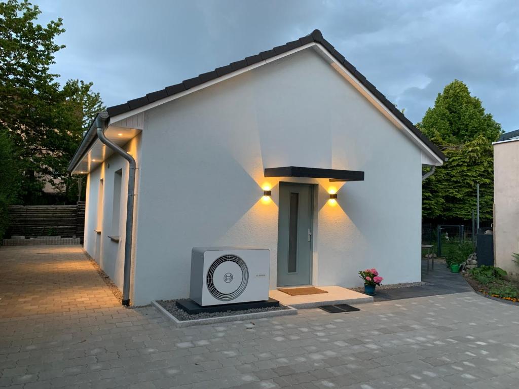 a small white house with a speaker in front of it at Ferienhaus Riemanns Refugium in Eutin