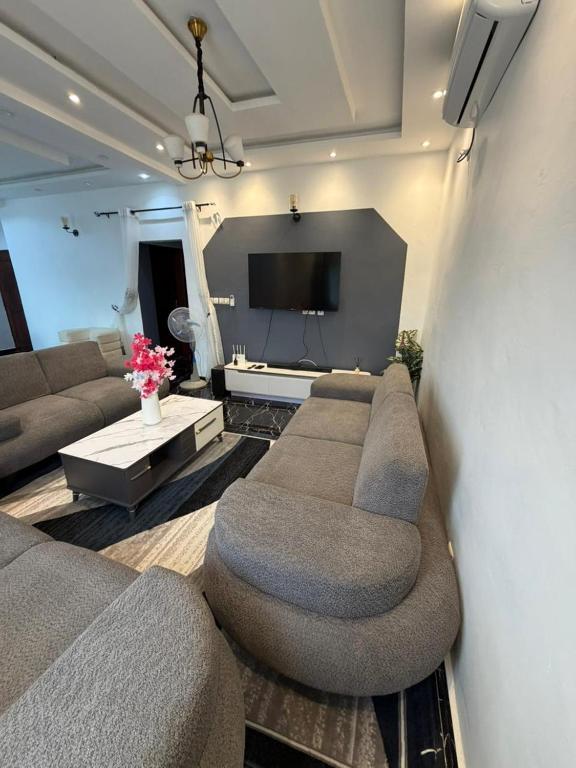 ein Wohnzimmer mit zwei Sofas und einem Flachbildfernseher in der Unterkunft Palace M&E in Douala