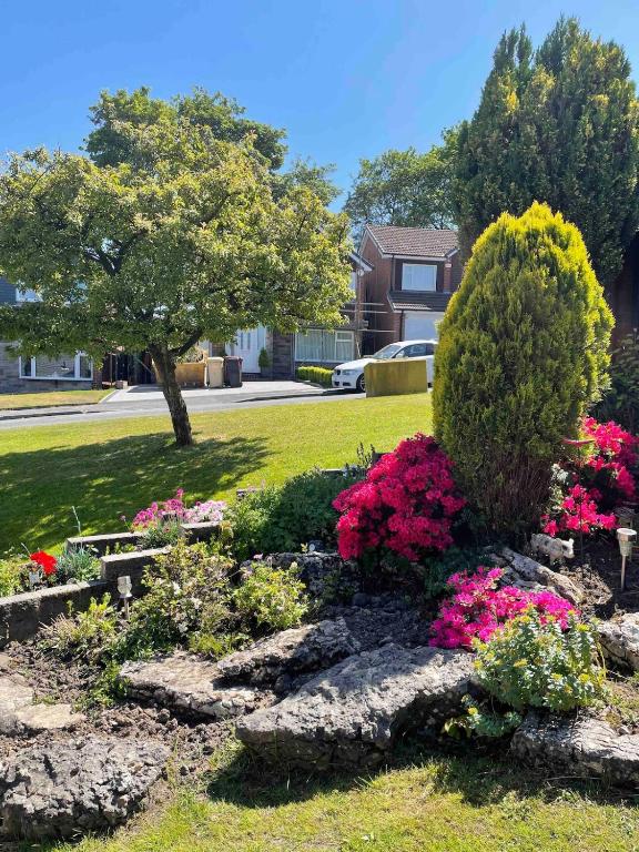 a garden with pink flowers in a yard at The Hideaway-Sharples-Bolton in Bolton
