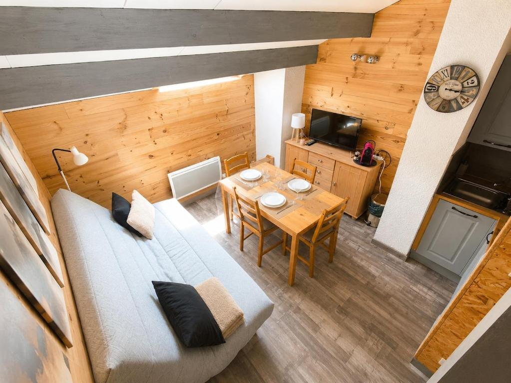 a living room with a couch and a table and a kitchen at Le Nid de Formiguères in Formiguères
