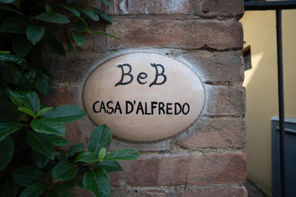 a sign on the side of a brick wall at Casa di Alfredo Affittacamere in Siena