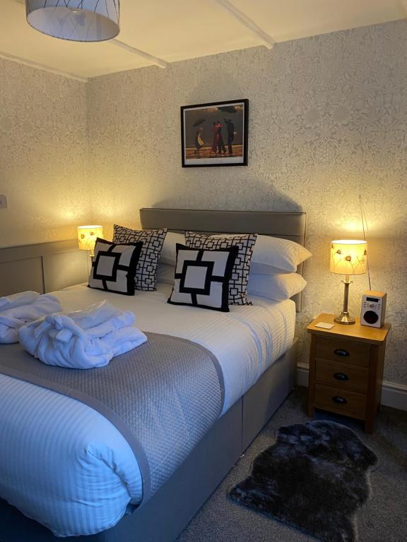 a bedroom with a bed with pillows and a night stand at Cobweb Cottage in Patrington