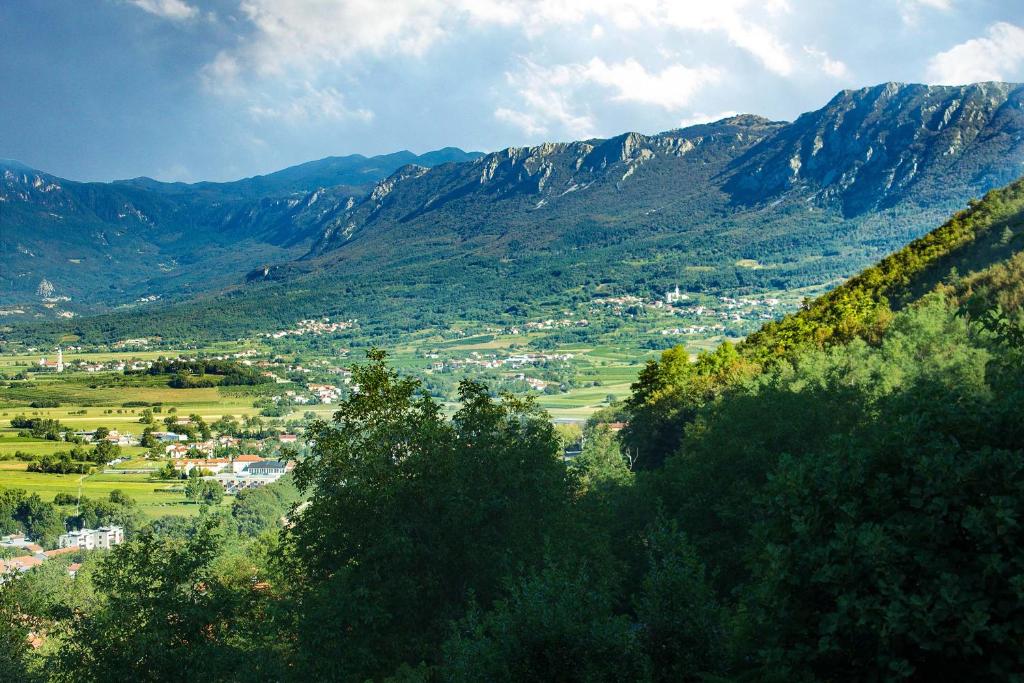 Blick auf eine Stadt in einem Tal mit Bergen in der Unterkunft Farm Stay Ferjančič in Vipava