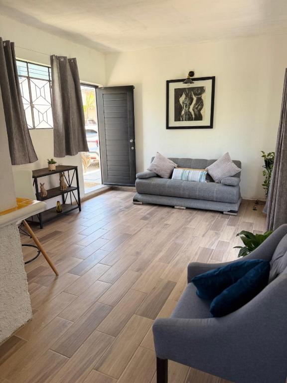 ein Wohnzimmer mit zwei Sofas und einem Holzboden in der Unterkunft CasaPalmitas in Las Varas