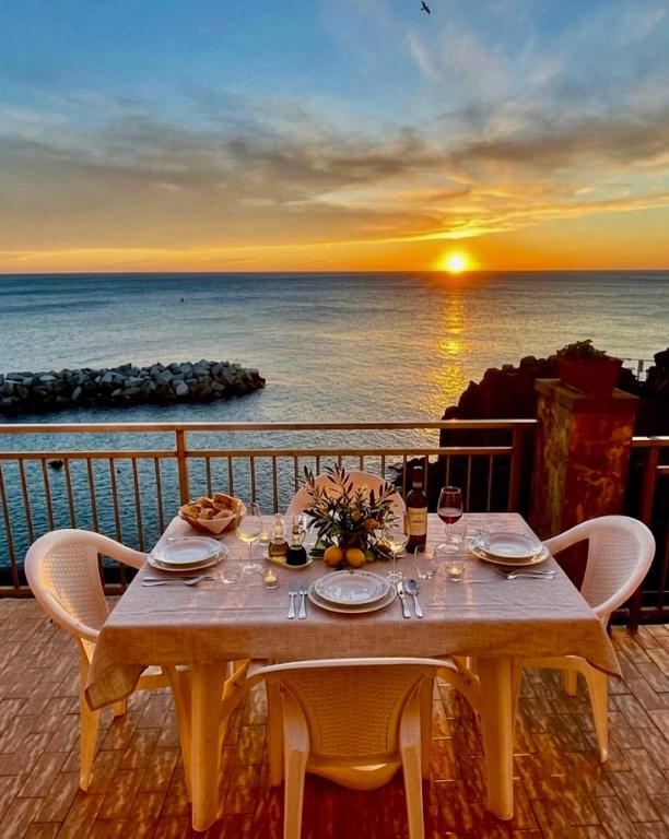 a table on a balcony with a view of the ocean at la Chiglia in Riomaggiore