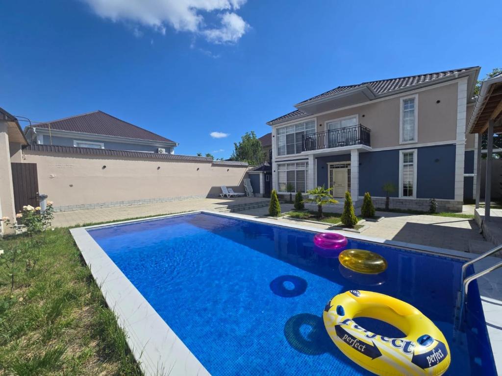 a swimming pool with a inflatable ball in front of a house at Rest Paradise Villa Gabala in Gabala