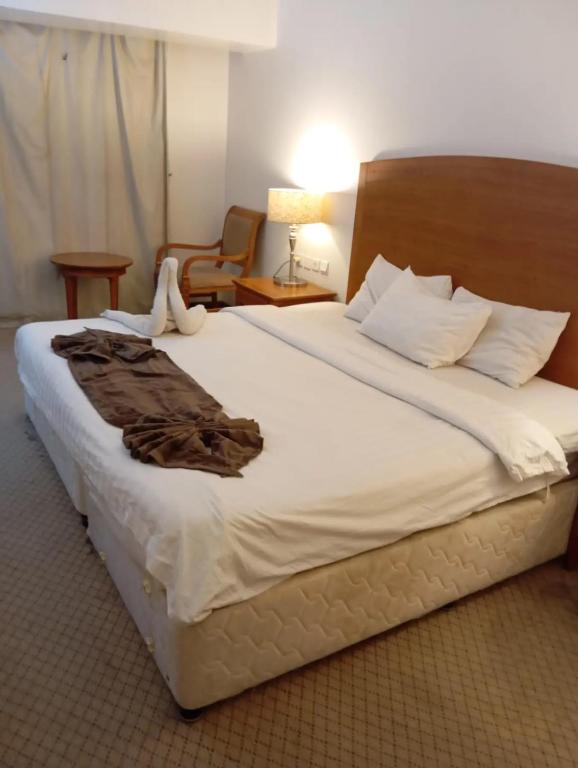a bedroom with a large bed with a robe on it at Room Al-Malaz in Riyadh