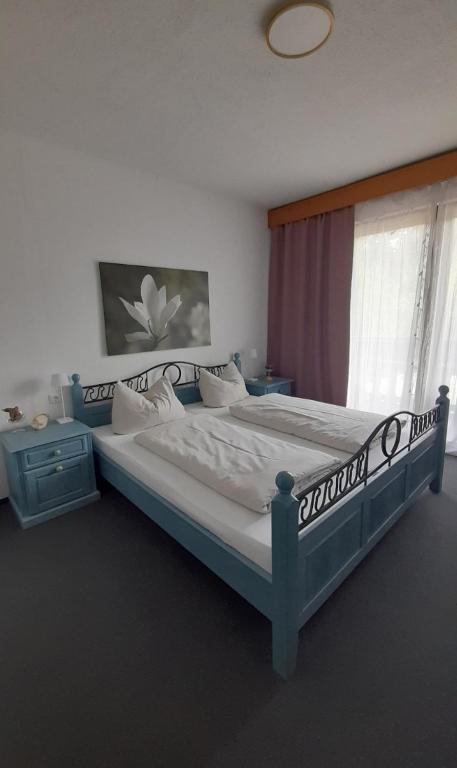 a bedroom with a bed with a blue frame and a window at Urlaub by Julka in Ledenitzen
