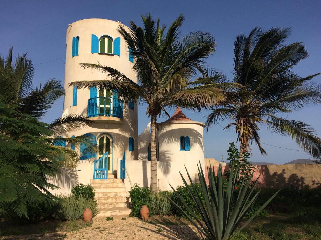 ein weißes Haus mit Palmen davor in der Unterkunft Torre Sabina in Vila do Maio