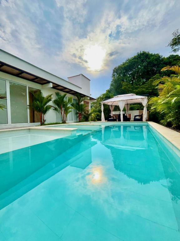 a swimming pool with blue water in front of a house at Quinta Samalu in Villavicencio