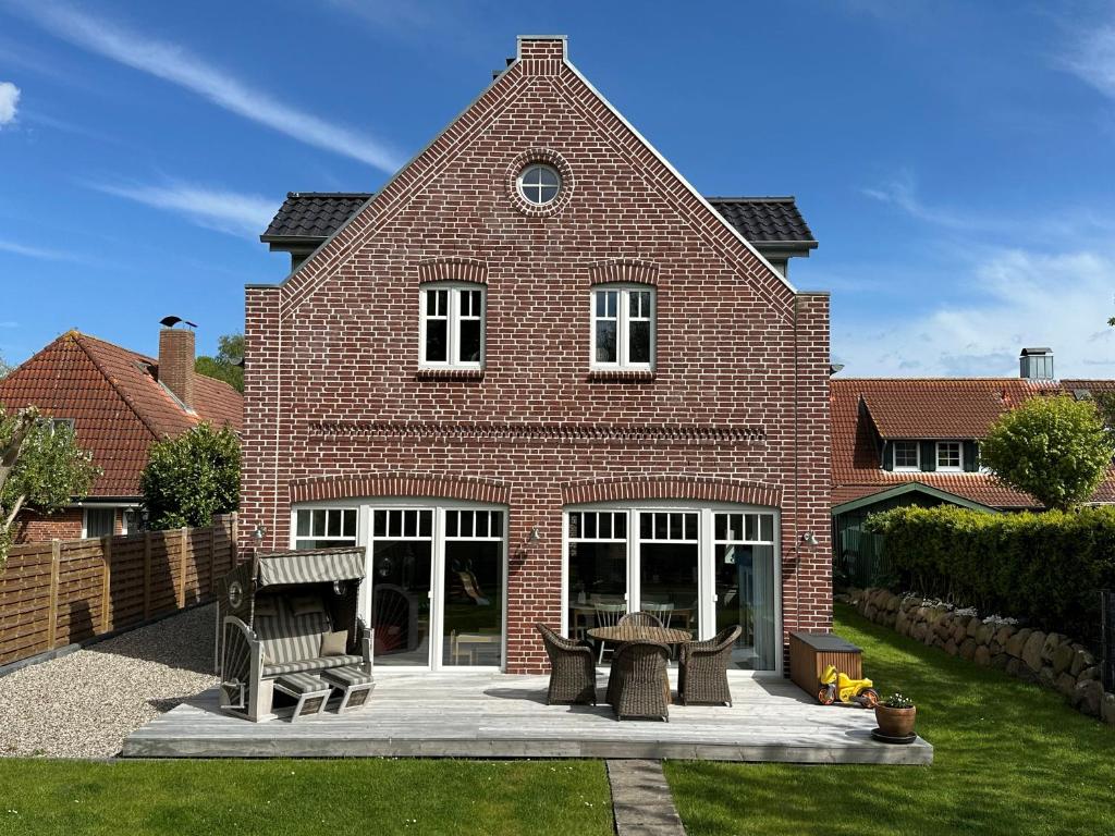 a brick house with a table and benches in front of it at Linnebarg Hus 4 in Fehmarn