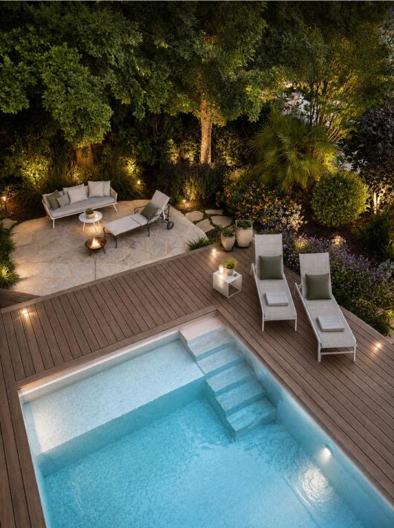 a backyard with a swimming pool and a wooden deck at Atelier Luma in Zikhron Ya'akov