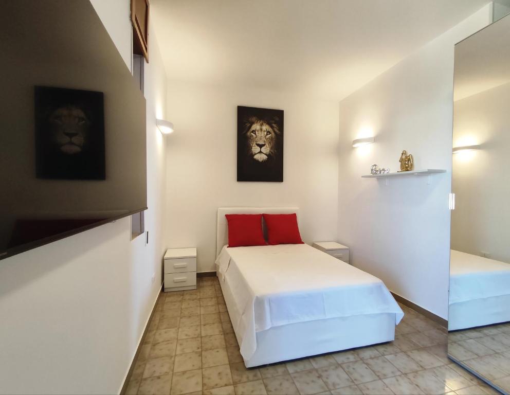 a small bedroom with a white bed and a red pillow at baia verde holiday in Baia Verde