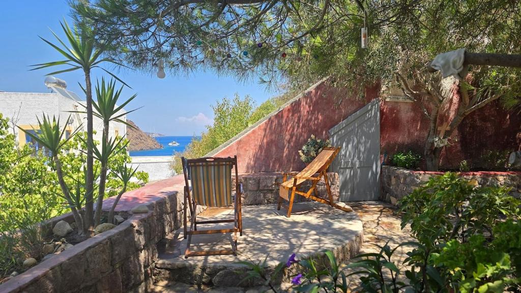 a couple of chairs sitting in a garden at Persephone's Home in Skala