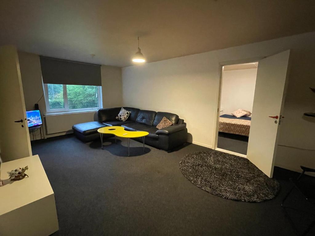 a living room with a couch and a table and a bed at Cozy & Private House in Roslev
