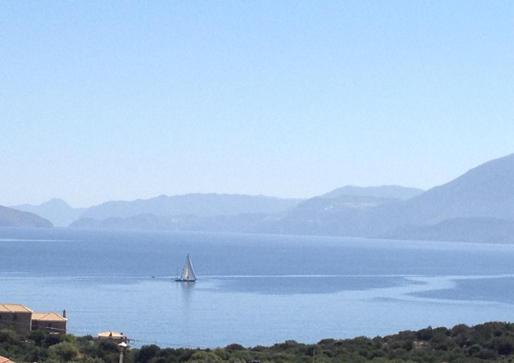 a sailboat in the middle of a large body of water at Fissi Villas agritourism accommodation near the sea in Agios Nikolaos