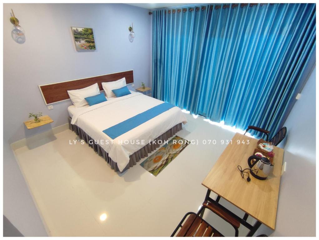 a bedroom with a bed and a blue curtain at Ly Guest House-Long Set Beach in Kaôh Rŭng (3)