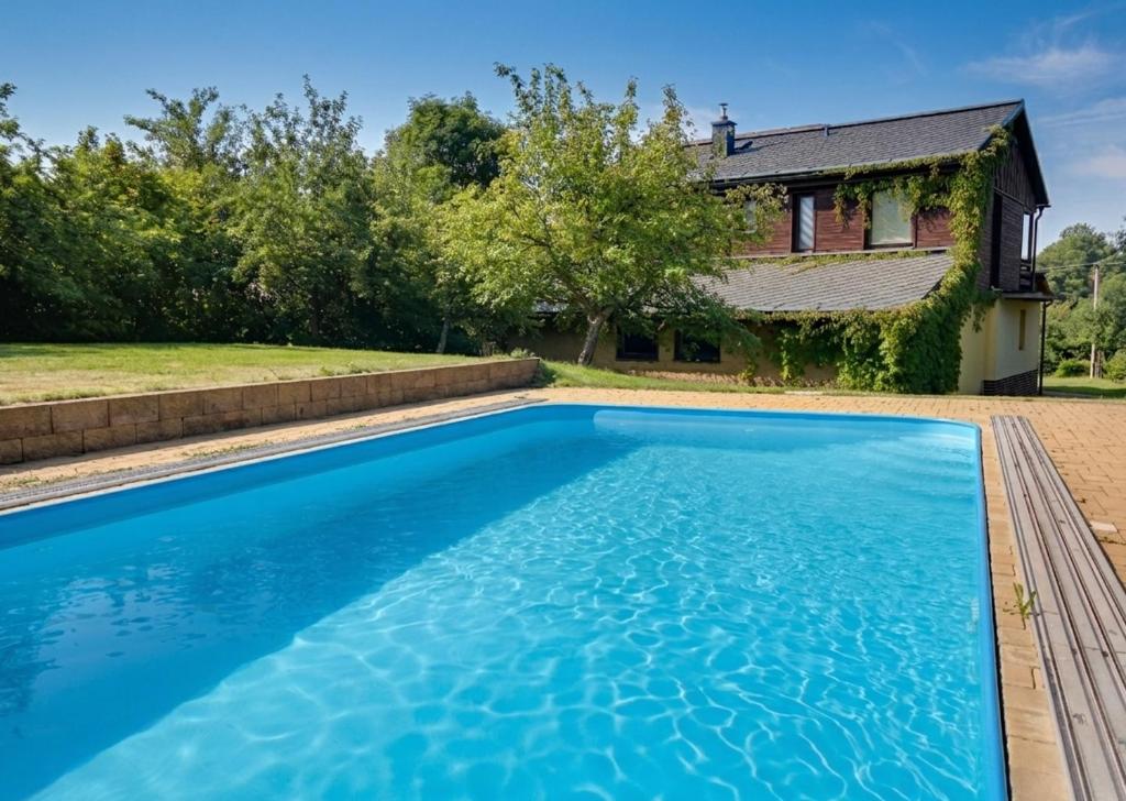 a swimming pool in front of a house at Chata Pod Hájkem in Vrchlabí