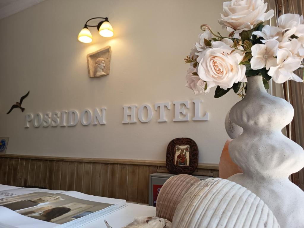 a vase filled with white flowers sitting on a table at Possidon in Agia Marina Aegina