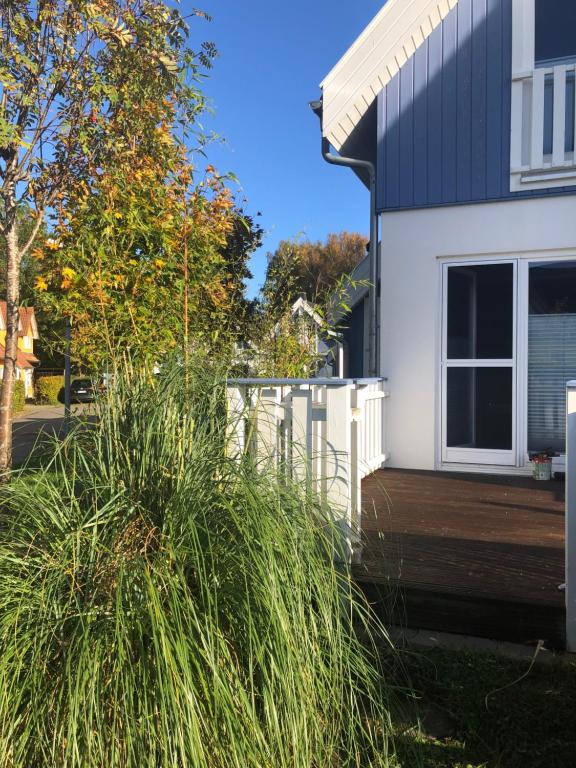 a house with a white fence and a wooden deck at Strandläufer in Breege