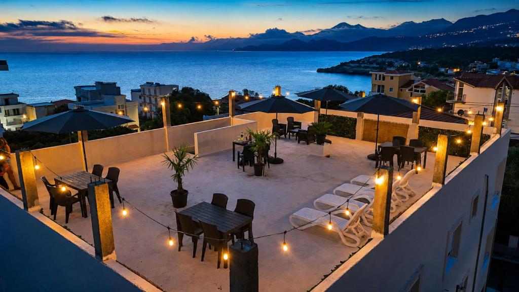 a rooftop patio with tables and umbrellas at night at Apartments and Studios Anicic in Utjeha