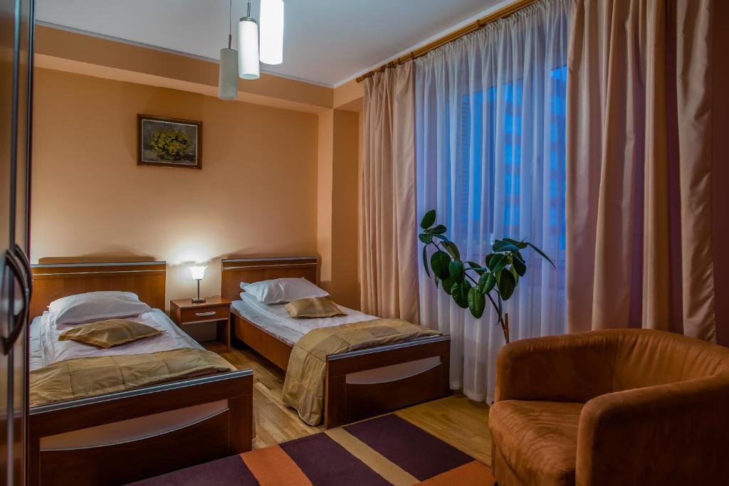 ラダウツィにあるHotel Mariaのベッド2台と窓が備わるホテルルームです。