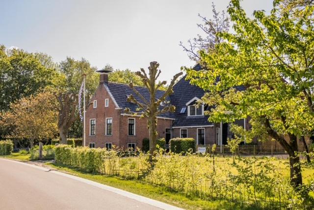a large brick house on the side of a road at Boerderij 1811 in Harich