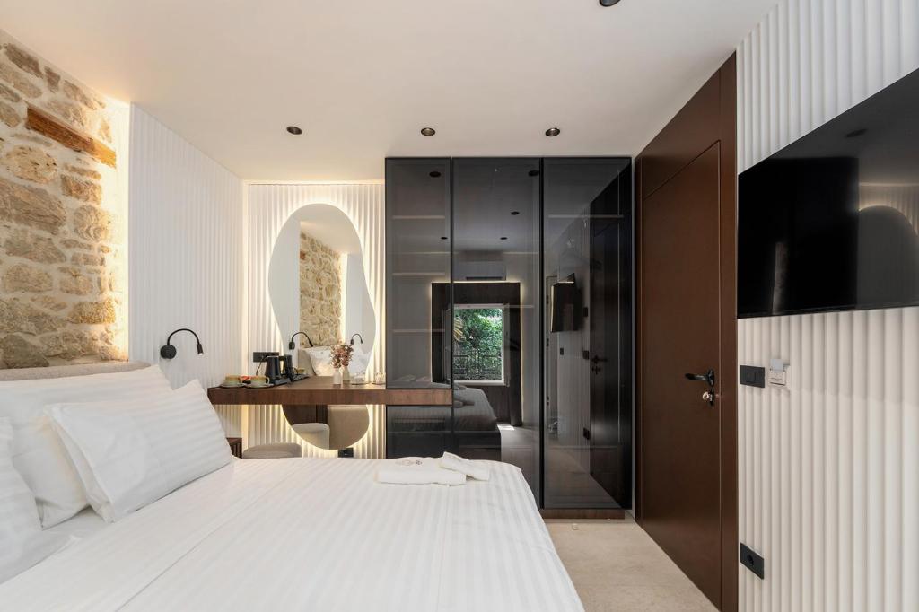 a bedroom with a large white bed and a desk at Una Rooms in Poreč