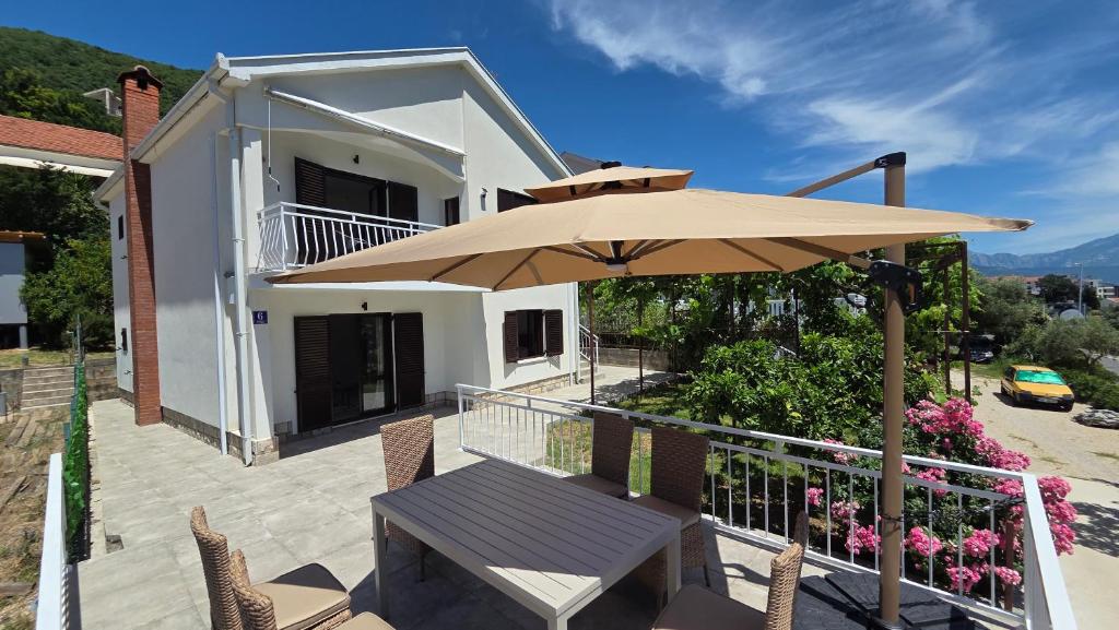 a patio with a table and an umbrella at Villa Sava in Đenovići