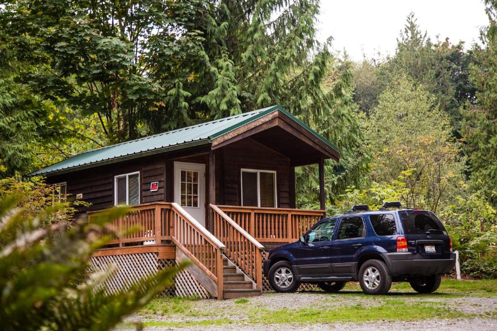 un coche aparcado delante de una casa pequeña en Mount Vernon Camping Resort Studio Cabin 5, en Bow